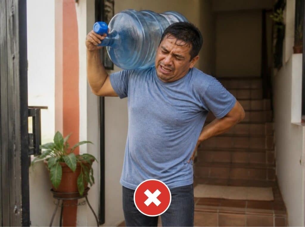 Persona cansada con dolor de espalda cargando un botellón de agua